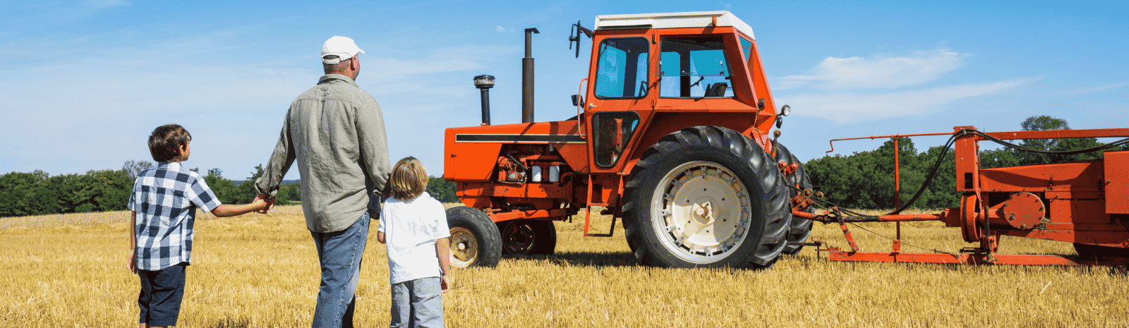 Farmer and sons looking at tractor