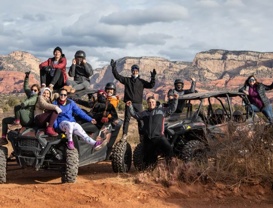 large group of people in ATVs with mountains in the background