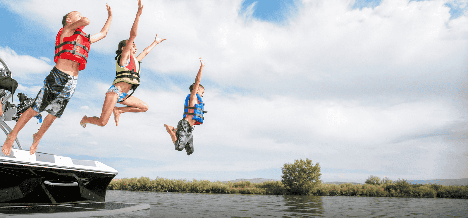 3 children jumping from boat into water