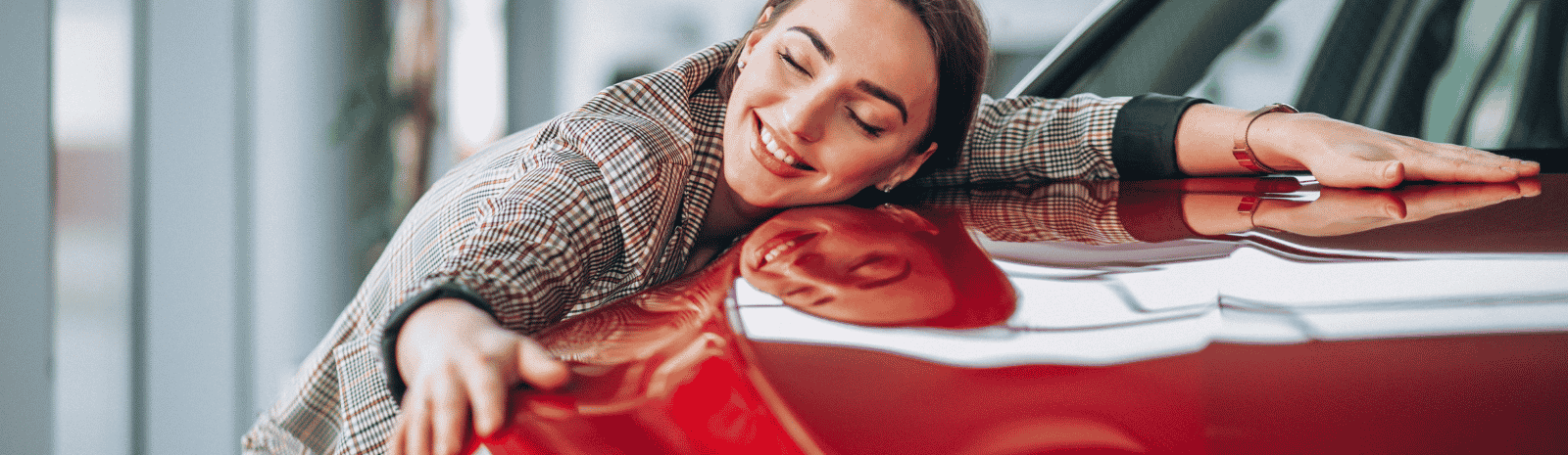 woman hugging new red car
